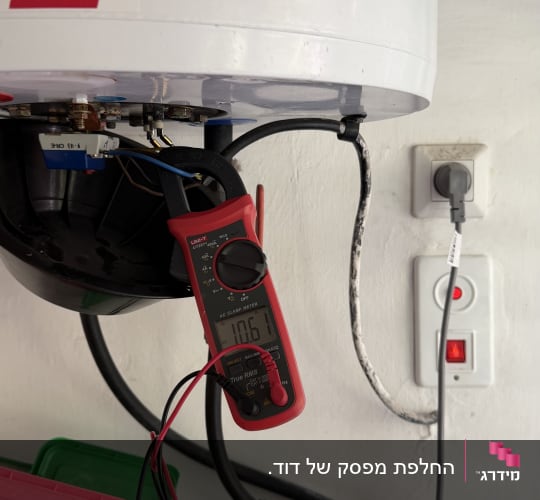 מד חום מחובר לדוד שמש על קיר